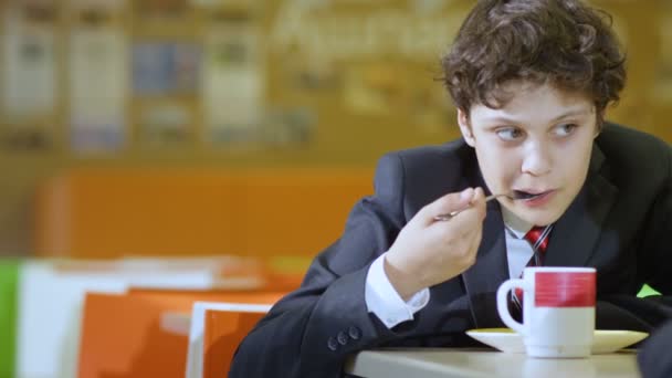 Escolar comiendo gachas en la cafetería de la escuela — Vídeos de Stock