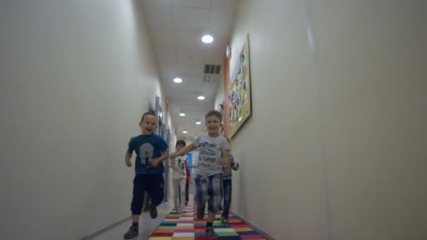Anak-anak berlari di sepanjang koridor di taman kanak-kanak — Stok Video