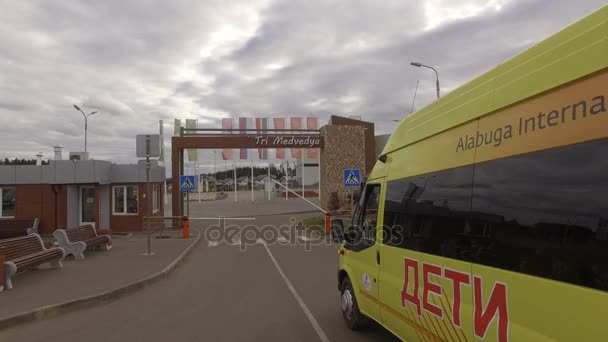 Желтый школьный автобус проезжает через КПП — стоковое видео