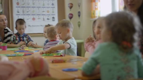 Дети, делающие бумажные изделия в детском саду — стоковое видео