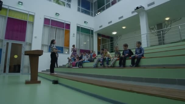 Professor conversando com crianças pequenas no jardim de infância — Vídeo de Stock