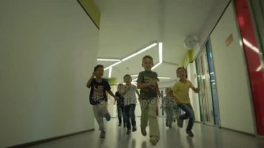 Anaokulunda koridor boyunca çalışan çocuk 