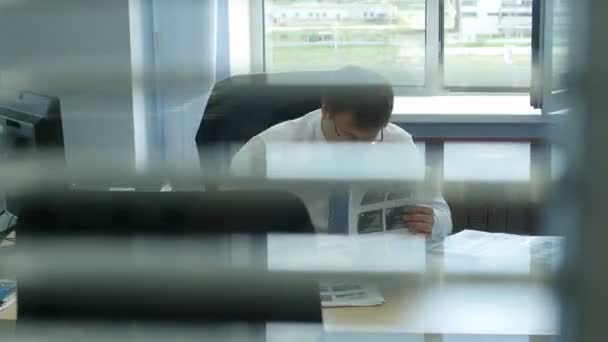 Uomo che lavora sul posto di lavoro in un ufficio leggero — Video Stock