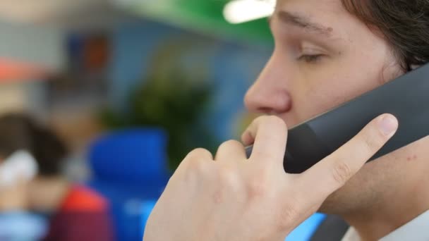 Hombre hablando por teléfono en el lugar de trabajo en la oficina — Vídeos de Stock