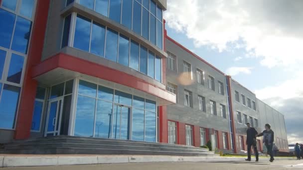 Gente caminando por la fachada del edificio industrial — Vídeos de Stock