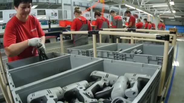 Рабочие в красных мундирах, собирающие сверла — стоковое видео