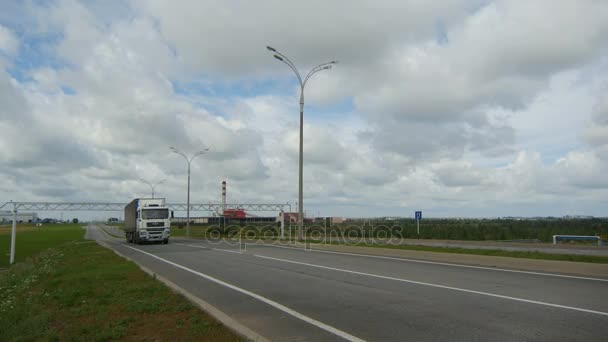 Грузовик движется по дороге рядом с заводом — стоковое видео