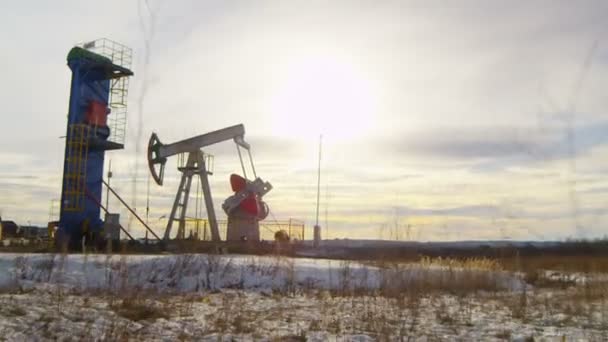 Onshore Pump Jack Funciona Perto Grande Torre Azul Entre Com — Vídeo de Stock