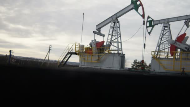 Κάμερα Δείχνει Μεγάλο Χάλυβα Pumpjacks Χρωματιστά Άλογα Λειτουργούν Κατά Συννεφιασμένο — Αρχείο Βίντεο