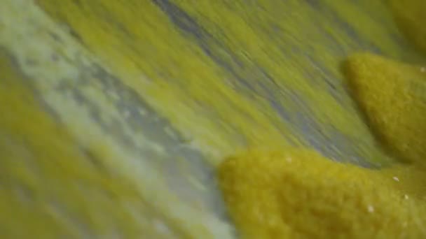 閉じるカメラは タイヤ製造プロセスの上から下に落ちる小さな黄色の硫黄粒子を示しています — ストック動画