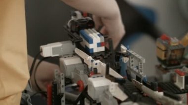 Tuğlalardan yapılmış yakın plan. Oyuncak yolda taşınıyor. Sundurmacı adam yolun sonunda alıyor.