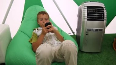 sandalyede oturan ve oyun oynama çocuk