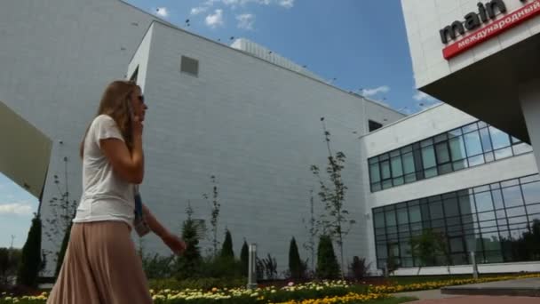 Девушка и мужчина идут в Главный международный центр — стоковое видео