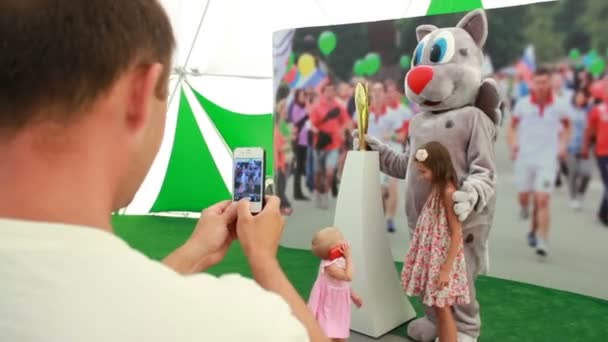 Baba kedi kostümlü animatör ile küçük kız pozlar — Stok video