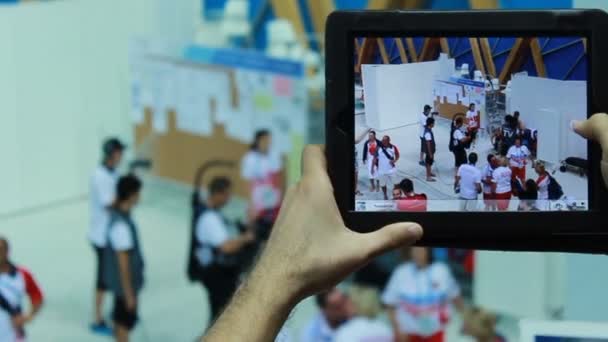 Homem tirando fotos de participantes da competição esportiva — Vídeo de Stock