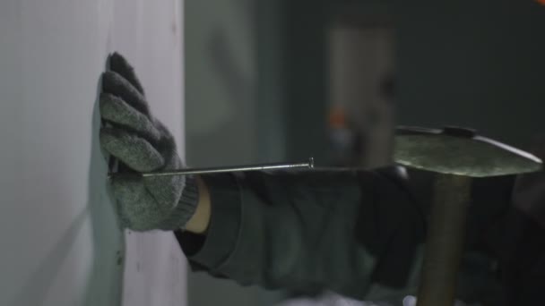 Werknemer spijkeren piek in de muur met hamer — Stockvideo