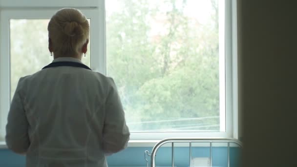 Infirmière en robe médicale marchant à travers la salle — Video