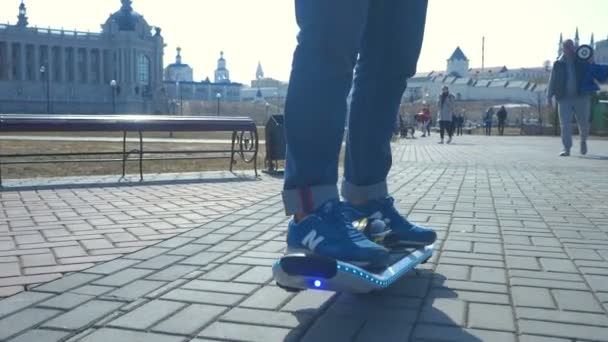 俄罗斯 2016年2月04日 酷男孩青少年驾驶现代电动滑板设备与蓝色光沿美丽的广场在2月04日在喀山 鞑靼阳光明媚的一天 — 图库视频影像