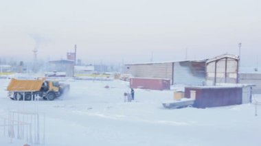 Salehard, Yamal-Nenets / Rusya - 15 Haziran 2012: 15 Haziran 'da Salehard' da kar ve yürüyen insan otomobilleri ve atölye binalarıyla kaplı üretim tesisi boyunca hareket