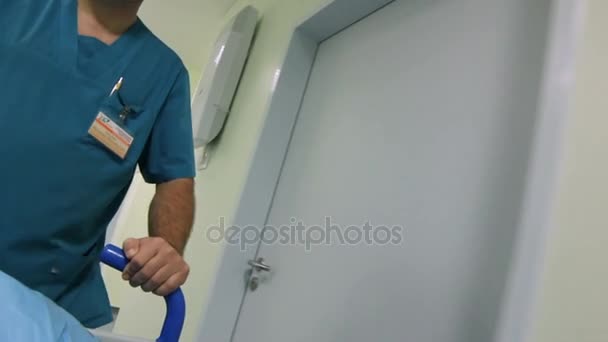 Dokter membawa pasien sepanjang aula rumah sakit — Stok Video