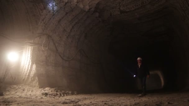 Trabajador caminando a lo largo de túnel oscuro — Vídeo de stock