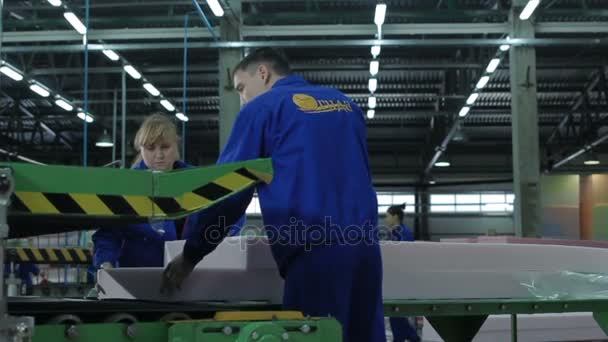 Trabajadores que fijan hojas de goma en la máquina — Vídeo de stock