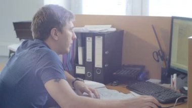 Kazan, Tataristan/Rusya - 11 Mayıs 2016: Yan görünümü gri gömlek genç konsantre mühendisi bilgisayarda Office belgeleriyle 11 Mayıs kazan çalışır