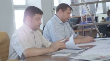 Kazan, Tataristan/Rusya - 11 Mayıs 2016: Yan görünümü erkeklerde ışık gömlek oturup ve belgeleri üzerinde 11 Mayıs kazan modern şık ofis kurumsal toplantısında bakmak