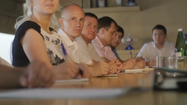 俄罗斯 2016年5月11日 人们坐着听报告 并作出笔记与钢笔在会议上长桌在5月11日在喀山的现代办公室 — 图库视频影像
