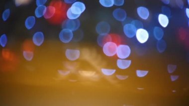 Kamera, yılbaşı süslemesinde parlayan bulanık mavi ve kırmızı ışık noktaları boyunca hareket eder.