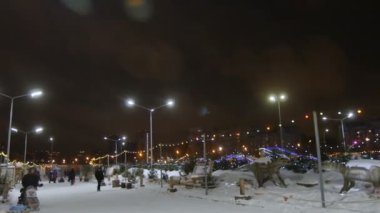 Kazan, Tataristan / Rusya - 13 Aralık 2016: İnsanlar 13 Aralık 'ta Kazan' da parkında parlayan ışıklar ve antik hayvan heykelleriyle süslenmiş çocuklarla yürüyorlar