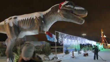 Kazan, Tataristan / Rusya - 13 Aralık 2016: 13 Aralık 'ta Kazan' da parlayan ışıklar ve yürüyen insanlara karşı Noel tarzında dekore edilmiş büyük bir dinozor heykeli