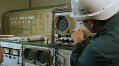 Kazan, Tataristan/Rusya - 12 Haziran 2016: Çalışan beyaz kask içinde aygıt parametrelerini ayarlar ve ölçüm Pano üzerinde 12 Haziran kazan okuma enstrüman erkek saatler