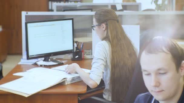 カザン タタールスタン共和国 ロシア連邦 2016 裏面表示の長い髪の女性は コンピューターで図面を職場で若い男前景カザンで — ストック動画