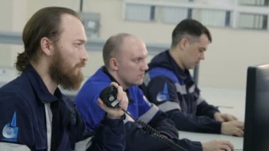 Kazan, Tataristan/Rusya - 20 Aralık 2016: Yan görünüm erkekler ön plan üzerinde taşınabilir radyo ile modern monitörler ve adam görev üniformalı 20 Aralık kazan konsantre