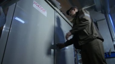 Kazan, Tataristan / Rusya - 20 Aralık 2016: Üniformalı orta yaşlı işçi büyük metal Jiskoot davasına geldi ve 20 Aralık 'ta Kazan' daki atölyenin kapısını açtı