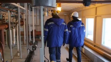 Kazan/Tataristan/Rusya - 20 Aralık 2016: kıyafet profesyonel çalışanları yürüyüş 20 Aralık kazan Petrol İşletme Bölümü metal ekipman yakınındaki ağır çekim arka görünümü
