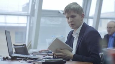 Kazan, Tataristan/Rusya - 20 Aralık 2016: Bilgisayar kağıtları genç profesyonel mühendis bakar ve 20 Aralık kazan meslektaşım arka planda orta yaşlı adam danışır