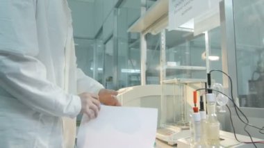 Kazan, Tataristan/Rusya - 20 Aralık 2016: Yan görünümü genç laboratuvar asistanı olarak Beyaz önlük çalışma araç görünüyor ve notlar 20 Aralık kazan laboratuvar günlükte yapar