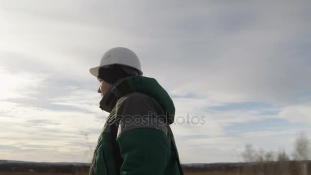 Werknemer in uniforme wandelen langs veld — Stockvideo