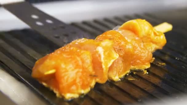 宏灶用金属厨房用刮刀在木棍上烤鸡柳进行调整 — 图库视频影像