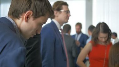 Kazan, Tataristan/Rusya - 13 Eylül 2017: Ofisteki ciddi erkekler arasında şık Kırmızı elbiseli genç çekici kadın büyük salonunda sergi 13 Eylül kazan uygun