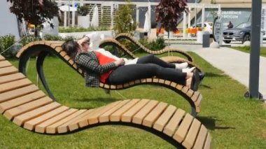 Kazan, Tataristan/Rusya - 07 Eylül 2017: Portre yetişkin kadın iletişim ve park geri kalanı üzerinde Eylül 07 kazan için cephede yer alan ahşap banklar lay