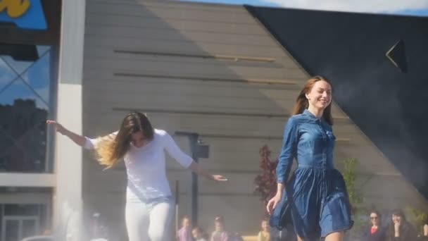 俄罗斯 2017年9月07日 慢动作美丽的笑的朋友跑沿上升的喷泉反对建筑学大厦在9月07日在喀山 — 图库视频影像