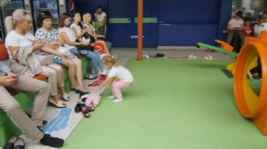 Kazan, Tataristan / Rusya - 19 Eylül 2017: Aileler, 19 Eylül 'de Kazan' da popüler bir alışveriş merkezinde yaratılan çocuk parklarında oynayan aktif çocukları bekleyen koltuklarda oturuyorlar