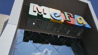 Kazan, Tataristan / Rusya - 18 Eylül 2017: Kamera, 18 Eylül 'de Kazan şehir merkezinde renkli Mega adı altında cam girişli mimari alışveriş merkezine gidenleri gösteriyor
