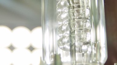 Rafineri kimya laboratuvarında şeffaf cam kapasite içinde metal çubuk etrafında makro spiral yapı