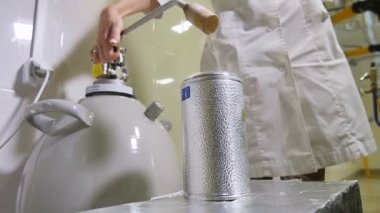 Yavaş çekim, yetenekli kimyager laboratuardaki metal tanktan sıvı nitrojen boşaltıyor.