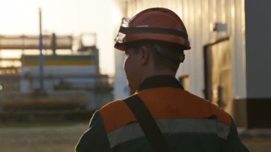 Yavaş çekim arka plan kalifiye işçiler gün ışığı altında büyük rafineri bölgesinde yürür