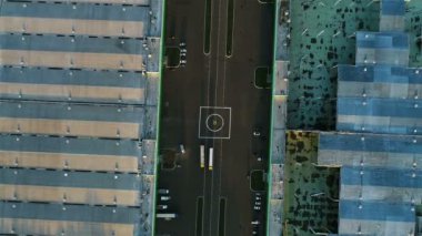 Havadan görünümü helikopter yolda metal çatılar ile büyük ambarlar arasında kamyonlar sürüş ile pad iniş